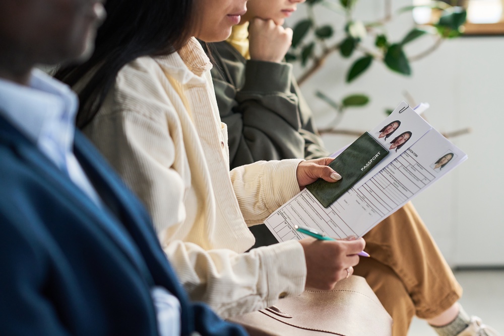 Image of a woman holding passport information in a waiting room.