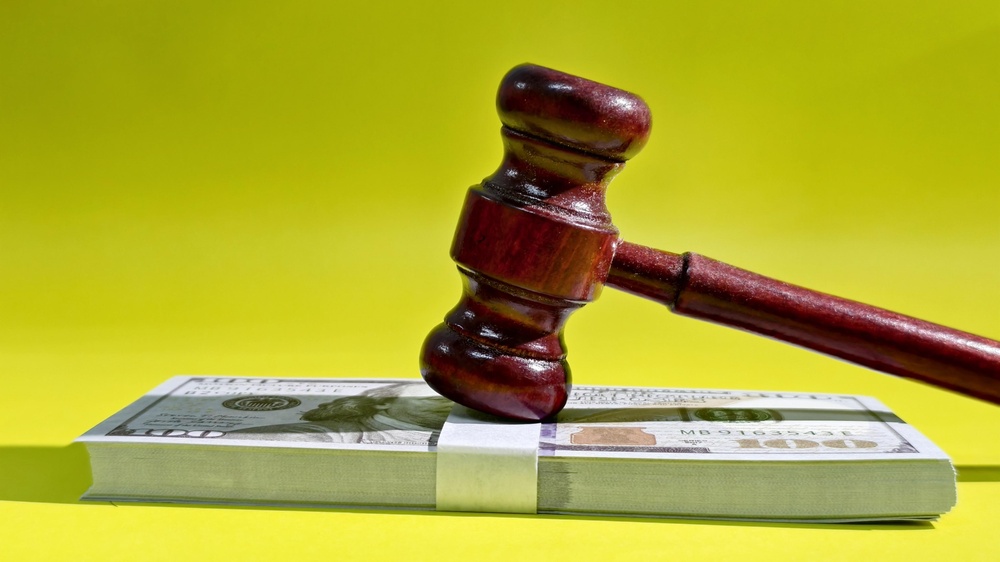 Image of a gavel and a stack of money.