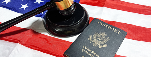 Decorative image of a U.S. flag with a passport and gavel on top of it.
