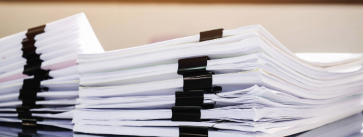 Image of stacks of papers with binder clips.