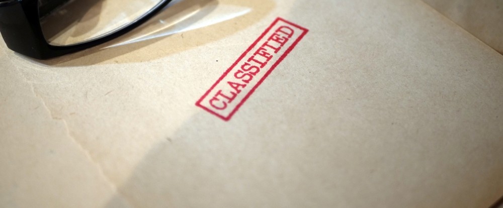Decorative image depicting a classified file on a desktop.